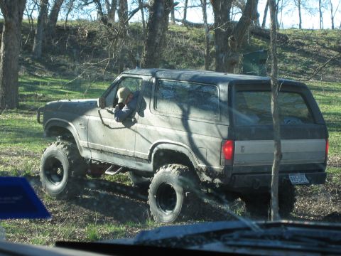 1996 Ford Bronco - This 1996 Ford Bronco navigates a muddy, wooded trail with its large off-road tires.