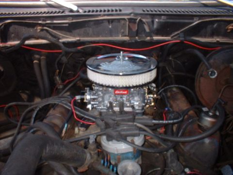 1979 Ford Bronco - Close-up view of an engine bay, focusing on the carburetor and air intake system.