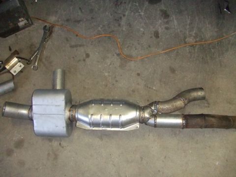 1995 Ford Mustang - A custom exhaust system part, likely for a vehicle, is shown laid out on a concrete floor.