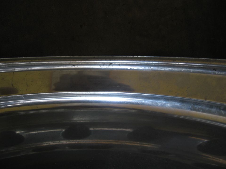 Close-up of a chrome wheel rim with some scratches and reflections
