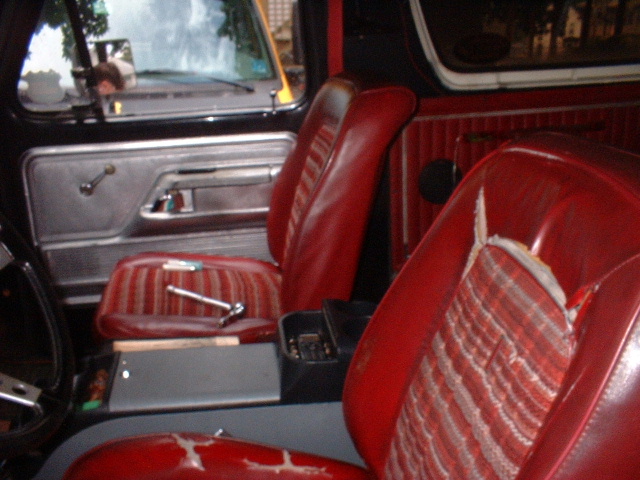 1979 Ford Bronco interior showing red striped seats and silver door panel