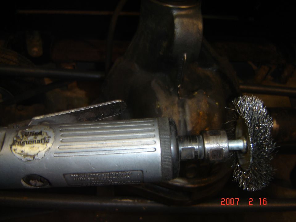 Air grinder with wire wheel attachment cleaning some metal part