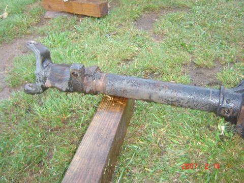 1993 Ford Bronco - A driveshaft component, likely from a vehicle, is shown outdoors resting on wooden supports.