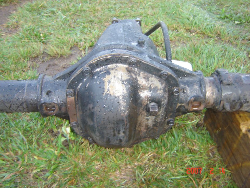 Rear axle differential assembly, likely from a truck or SUV, resting on grass