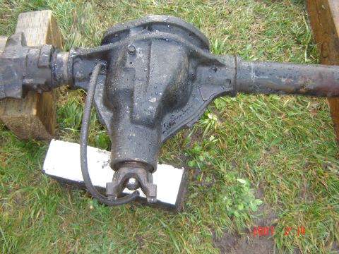 1993 Ford Bronco - A rear axle assembly sits on the grass, supported by wooden blocks.