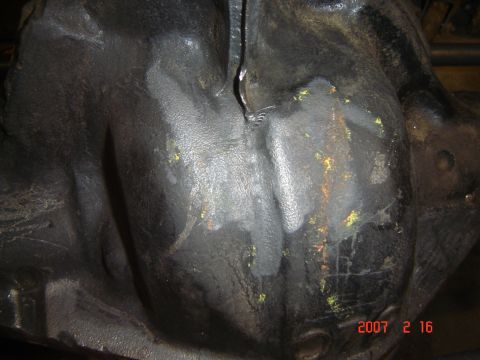 1993 Ford Bronco - Close-up view of a dark, textured underbody component with evidence of repair work.
