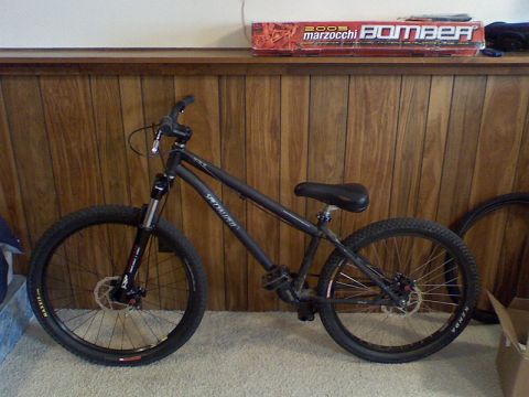 1997 Ford Probe - A black Specialized bicycle is shown indoors against a wood-paneled wall.