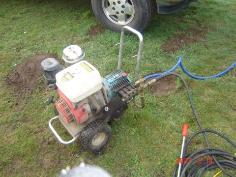 1993 Ford Bronco - Pressure washer and a vehicle tire are visible on the grass.