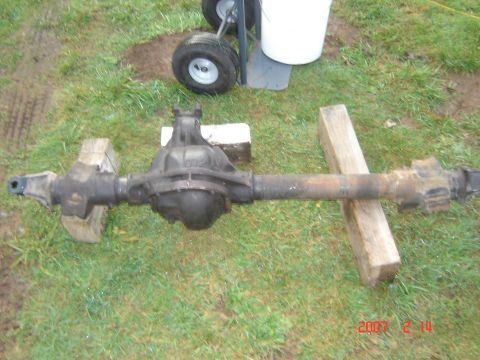 1993 Ford Bronco - A vehicle's rear axle assembly is shown resting on wooden blocks on a grassy surface.