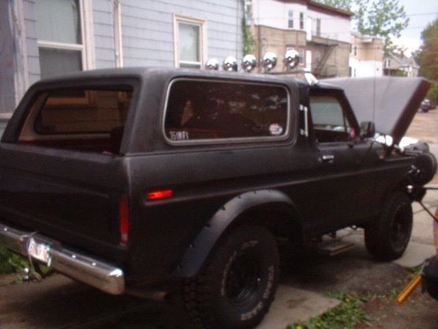 Black 1979 Ford Bronco, 3/4 front view, hood open, roof lights