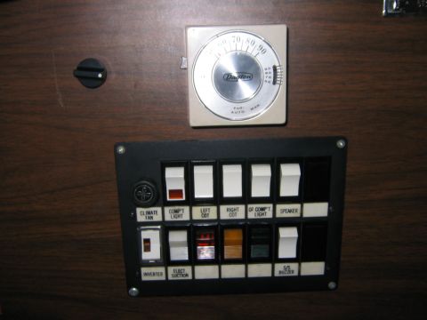 1984 Ford F-350 - Close-up of an RV's interior control panel, various switches and a thermostat.