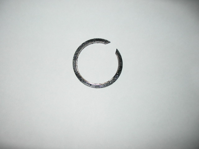 Broken metal ring with textured surface, isolated on white background