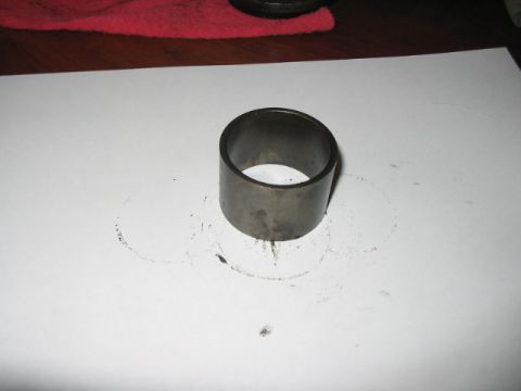 1991 Ford Bronco - A metal bushing is shown on a white surface, with smudges indicating its previous use.