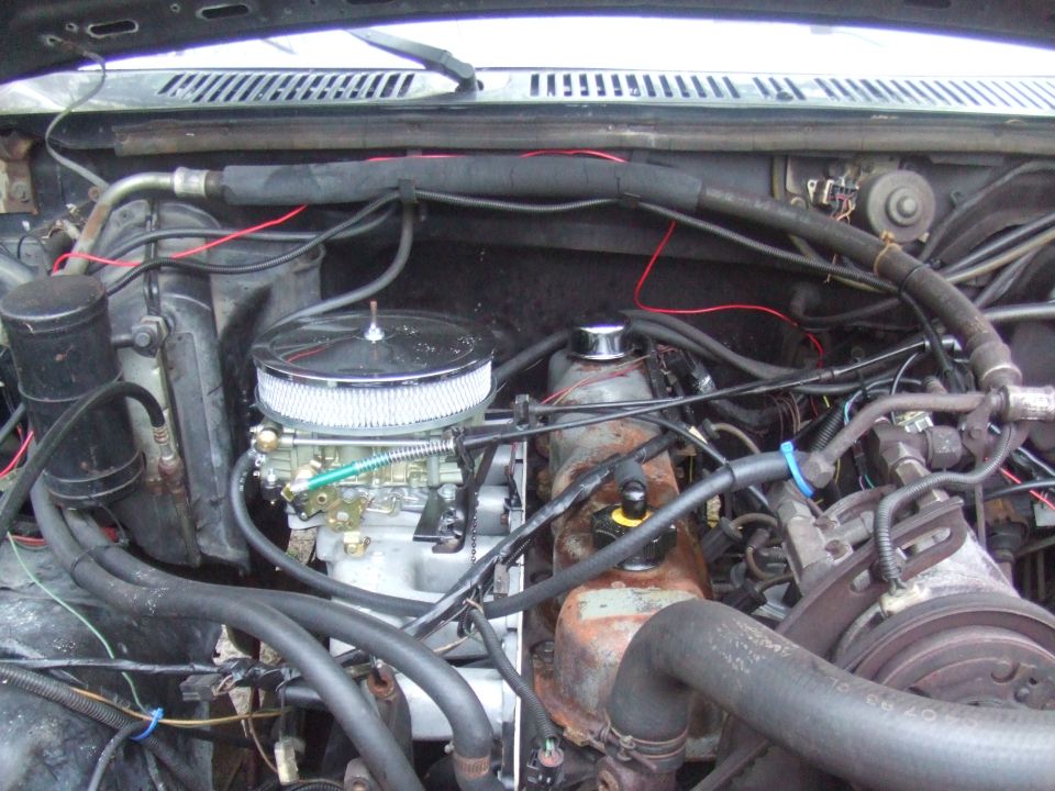 Engine bay with aftermarket carburetor and air cleaner