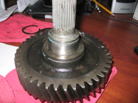 1991 Ford Bronco - Close-up of a gear and shaft assembly, likely a vehicle part, resting on a pink cloth on a wooden surface.
