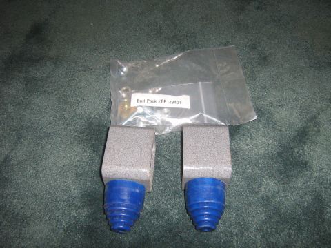 1995 Ford Bronco - A bolt pack and two suspension components with blue rubber boots are displayed on a dark carpeted surface.