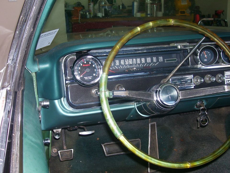 Green 1965 Pontiac Catalina interior dashboard with tachometer and speedometer