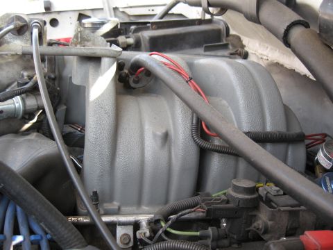 1994 Ford Bronco - Close-up view of an engine compartment, focusing on the intake manifold and associated wiring.