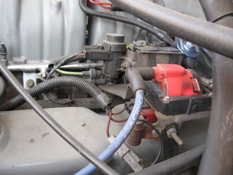 1994 Ford Bronco - Close-up view of an engine bay, a red MSD ignition coil and blue spark plug wires.