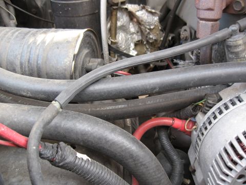 1994 Ford Bronco - Close-up view of an engine bay, showing various hoses, the alternator, and insulated components.