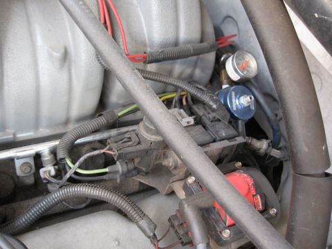 1994 Ford Bronco - Close-up view of engine components including a fuel pressure regulator and gauge.