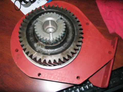 1991 Ford Bronco - A close-up view of a red metal gear assembly with two interlocking gears.