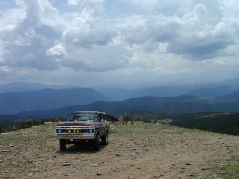 1979 Ford Bronco - A vintage Ford truck sits on a mountain overlook under a cloudy sky.