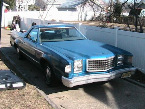 1973 Ford Ranchero - A blue Ford Ranchero is parked in a residential driveway, showing its front grille and headlights.