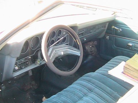 1973 Ford Ranchero - Interior view of a 1973 Ford Ranchero, blue velour upholstery and a dashboard with multiple gauges.