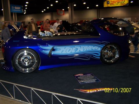 1979 Ford F-150 - A customized blue car with Hot Wheels graphics is displayed indoors on a black carpet.
