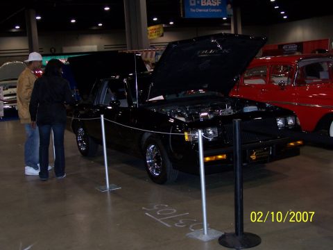 1979 Ford F-150 - A black Buick Grand National is displayed with its hood open, parked next to a red classic car.