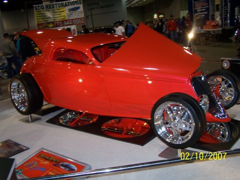 1979 Ford F-150 - A bright red custom hot rod is displayed indoors with its hood open, showing off its custom features.