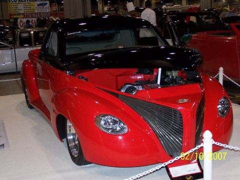 1979 Ford F-150 - A custom hot rod with a two-tone paint scheme is displayed indoors, with its hood open to reveal the engine.