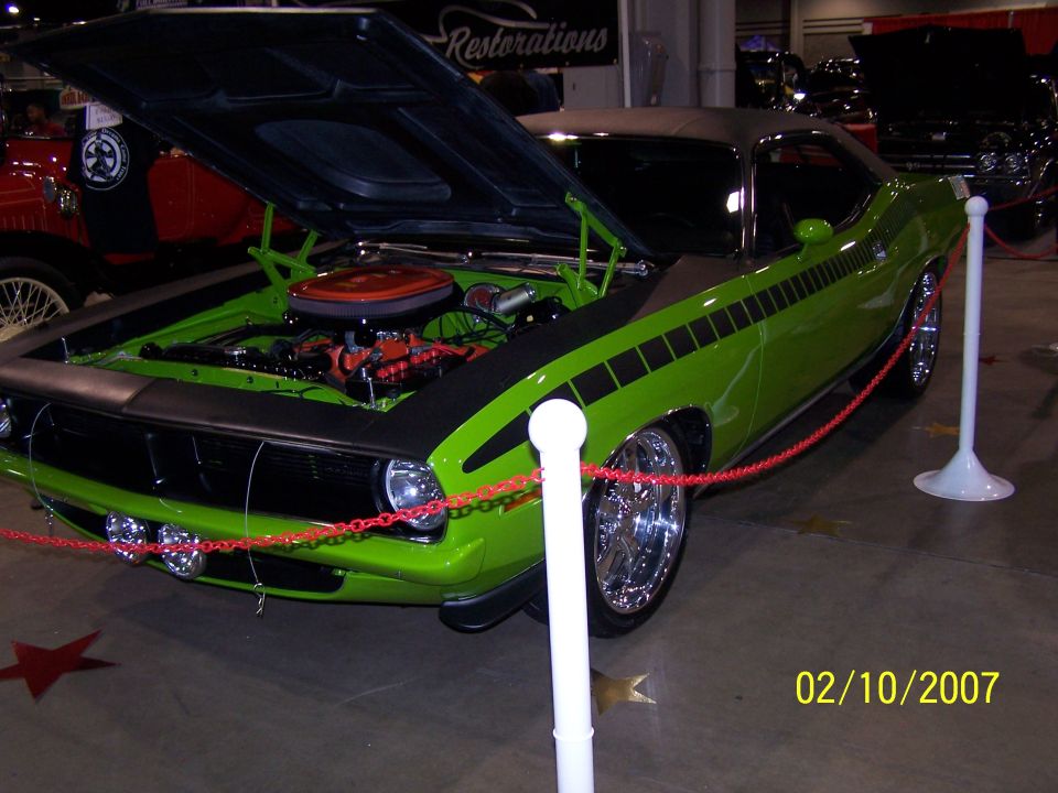 Lime green muscle car, hood open showing engine. Black stripe on fender and door. Chrome wheels