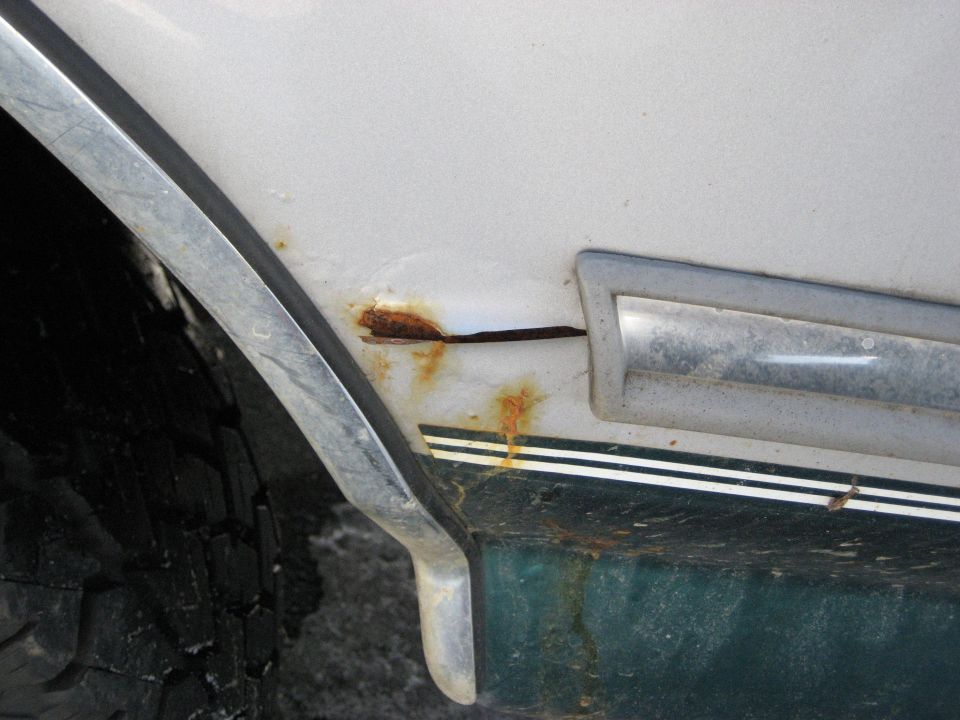 1994 Ford Bronco fender with rust and chrome trim