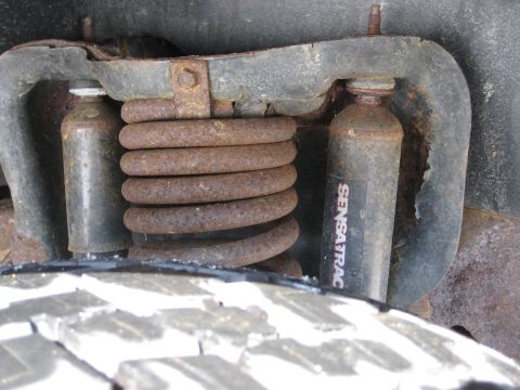 1994 Ford Bronco - Suspension components including a coil spring and a shock absorber are visible near a tire.