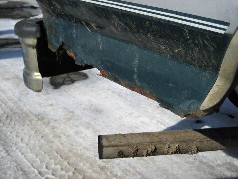 1994 Ford Bronco - Close-up of a rusted lower body panel on a vehicle, showing significant corrosion.