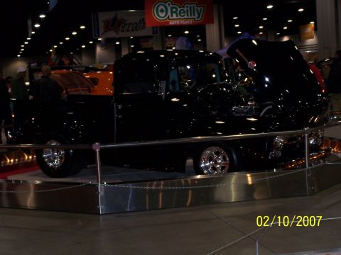 1979 Ford F-150 - A black pickup truck is displayed indoors with its hood open, its engine bay.