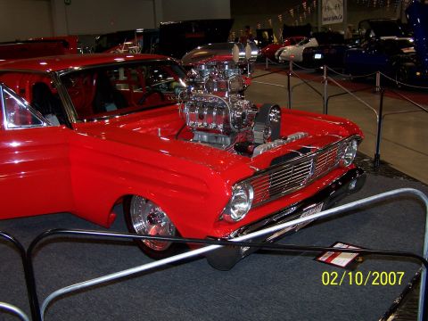 1979 Ford F-150 - Customized red hot rod with a prominent supercharger displayed at a car show.
