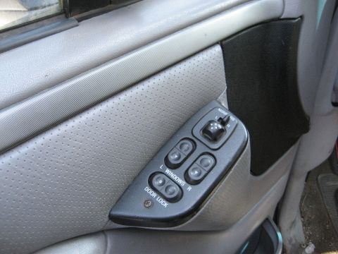 1994 Ford Bronco - The interior door panel features power window controls for both driver and passenger sides, along with a door lock switch.