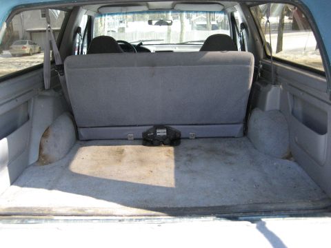 1994 Ford Bronco - Interior view of the cargo area in a 1994 Ford Bronco, showing the folded rear seat.