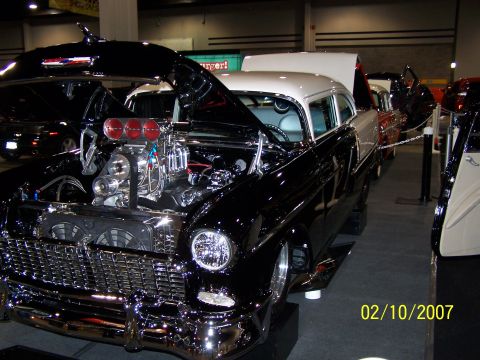 1979 Ford F-150 - A modified 1955 Chevrolet Bel Air is displayed with its hood open, revealing a powerful engine.