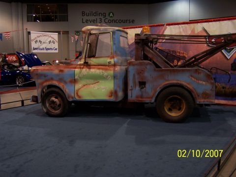 1979 Ford F-150 - A tow truck with a distressed paint job is displayed indoors, with other vehicles visible in the background.
