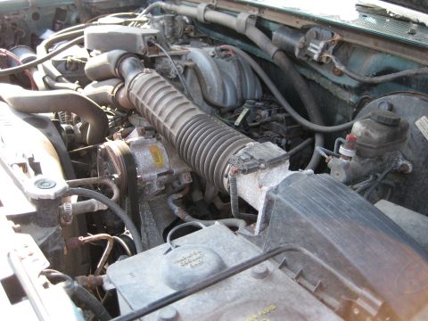 1994 Ford Bronco - Close-up view of a vehicle's engine bay, showing various components and hoses.