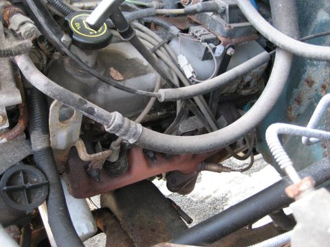 1994 Ford Bronco - The engine bay of a vehicle, with various components and wiring visible.
