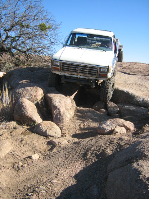 1986 Ford Bronco - This pickup truck navigates a challenging rocky trail, demonstrating its off-road capabilities.