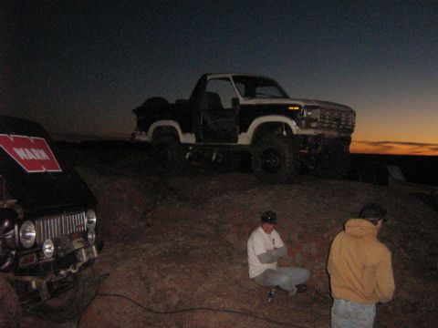1986 Ford Bronco - A lifted 1980s Ford Bronco, likely from the early 1980s, is seen with its doors off during an off-road excursion at dusk.