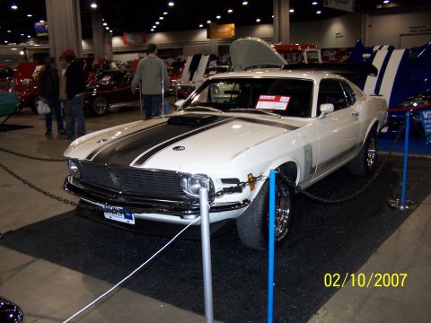 1979 Ford F-150 - White 1970 Ford Mustang Boss 302 with black racing stripes on hood and trunk, displayed indoors.