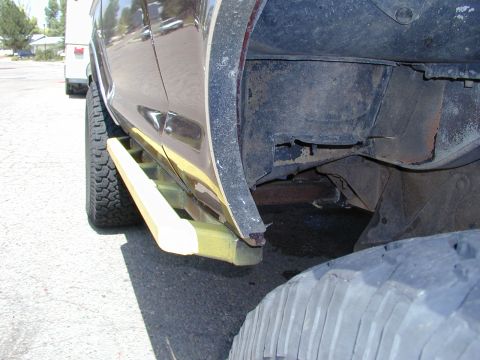 1979 Ford Bronco - Side view of a vehicle's wheel well and step bar, with 'SUPERMOTORS' branding on the tire.