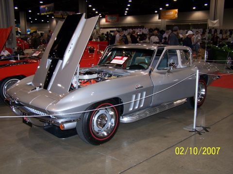 1979 Ford F-150 - A silver 1967 Chevrolet Corvette Sting Ray is displayed indoors with its hood open, showing the engine.